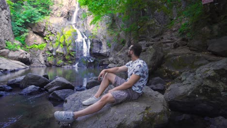 Young-man-watching-the-waterfall.